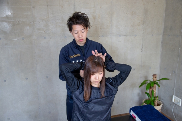 手を頭のうしろに組んで、後頭部のでっぱりの下を抑えます。